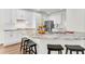 A well-appointed kitchen boasts white cabinets, granite countertops, a stainless steel refrigerator, and a center island with barstool seating at 3106 Soldier Trl, Marietta, GA 30068