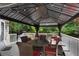 Relaxing outdoor deck featuring a gazebo with comfortable seating, a table, and scenic views of the surrounding trees at 3106 Soldier Trl, Marietta, GA 30068