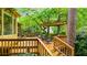 Inviting wooden back deck with pergola and seating, surrounded by lush greenery, providing a tranquil outdoor space at 3358 Stovehill Se Ct, Marietta, GA 30067