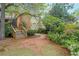 View of the backyard featuring lush greenery, a wooden deck, and a charming path leading through the garden at 3358 Stovehill Se Ct, Marietta, GA 30067