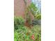 Brick exterior featuring lush greenery and vibrant red flowers, creating a private backyard oasis at 3358 Stovehill Se Ct, Marietta, GA 30067