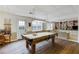 Finished basement with a pool table, built-in shelving, and ample seating area at 3358 Stovehill Se Ct, Marietta, GA 30067
