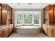 Luxurious bathroom with a large soaking tub nestled in a bay window and custom cabinets at 3358 Stovehill Se Ct, Marietta, GA 30067
