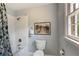 Bathroom with white subway tiled shower/tub, blue accents, and toilet near a window at 3358 Stovehill Se Ct, Marietta, GA 30067