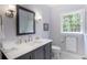 Bright bathroom with a modern vanity, framed mirror, and a window view of the lush outdoors at 3358 Stovehill Se Ct, Marietta, GA 30067