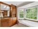 Bright bathroom with a soaking tub next to a large window, granite counters and wood cabinets at 3358 Stovehill Se Ct, Marietta, GA 30067