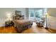 Cozy bedroom featuring hardwood floors, a comfortable bed, bay windows, and a relaxing armchair at 3358 Stovehill Se Ct, Marietta, GA 30067