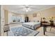 Spacious bedroom featuring a large window seat, ceiling fan, and classic decor at 5560 Stoneleigh Dr, Suwanee, GA 30024