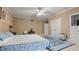 Bright bedroom features large bed, ceiling fan, a patterned rug, and multiple closet doors at 5560 Stoneleigh Dr, Suwanee, GA 30024