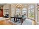 Dining area featuring large arched windows, chandelier, bench seating, and wood flooring at 5560 Stoneleigh Dr, Suwanee, GA 30024