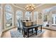Bright dining room with large arched windows, wood floors, chandelier, and door to the porch at 5560 Stoneleigh Dr, Suwanee, GA 30024