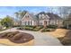 Stately brick home with manicured landscaping and a circular driveway at 5560 Stoneleigh Dr, Suwanee, GA 30024