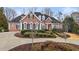 Elegant brick home with manicured landscaping and circular driveway at 5560 Stoneleigh Dr, Suwanee, GA 30024