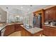 Open kitchen with granite countertops, stainless steel appliances, and wood cabinets, near dining area at 5560 Stoneleigh Dr, Suwanee, GA 30024