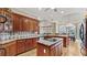 Kitchen view with wood cabinets, hardwood floors, granite countertops, and dining area at 5560 Stoneleigh Dr, Suwanee, GA 30024