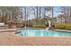 Outdoor pool with brick deck, jacuzzi, and adjacent grill area at 5560 Stoneleigh Dr, Suwanee, GA 30024