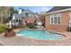 Beautiful backyard pool and spa with brick surround and attractive home architecture at 5560 Stoneleigh Dr, Suwanee, GA 30024