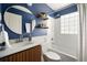 Stylish bathroom with a blue accent wall, modern vanity, and a tiled shower-tub combination at 720 Maynard Se Ter, Atlanta, GA 30316
