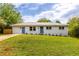 Charming single-story home with a metal roof, fresh white paint and vibrant blue doors and trim at 1755 Rockbridge Nw Rd, Conyers, GA 30012
