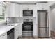 Updated kitchen with white cabinetry, stainless steel appliances and modern fixtures at 1755 Rockbridge Nw Rd, Conyers, GA 30012