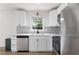 Modern kitchen featuring white cabinets, stainless steel appliances and a grey backsplash at 1755 Rockbridge Nw Rd, Conyers, GA 30012
