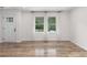 Sunlit living room with stylish hardwood floors, white curtains and fresh white paint at 1755 Rockbridge Nw Rd, Conyers, GA 30012