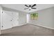 A neutral bedroom with gray carpet, a ceiling fan, and doors that lead to other rooms at 1829 Herringbone Holw, Lithonia, GA 30058