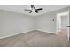 A bedroom with gray carpet, neutral paint, and a ceiling fan, next to what may be the primary bath at 1829 Herringbone Holw, Lithonia, GA 30058