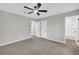 A bedroom with light gray walls and carpet, ceiling fan, and a door leading to another room at 1829 Herringbone Holw, Lithonia, GA 30058