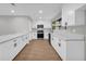 Kitchen boasts white cabinets, quartz counters, stainless appliances, and wood floors at 1829 Herringbone Holw, Lithonia, GA 30058