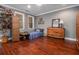 Bedroom with wood floors, grey walls, two windows, and a dresser with a mirror and lamp at 3025 Woodwalk Se Dr # 17, Atlanta, GA 30339