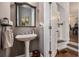 Stylish powder room with pedestal sink, decorative mirror, and convenient access to the staircase at 3025 Woodwalk Se Dr # 17, Atlanta, GA 30339