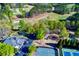 Aerial view of golf course, tennis courts, playground, pool, and clubhouse nestled in lush greenery at 5010 Winding Hills Ln, Woodstock, GA 30189