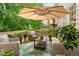 An inviting outdoor porch features wicker furniture, a shade umbrella, and lush greenery at 5010 Winding Hills Ln, Woodstock, GA 30189