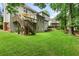 Spacious backyard featuring a deck, lush green lawn, and mature trees offering shade at 5010 Winding Hills Ln, Woodstock, GA 30189