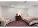A cozy finished basement bedroom space with an area rug, dresser and comfortable chair at 5010 Winding Hills Ln, Woodstock, GA 30189