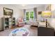 Bright Bedroom with a crib, pink chair, and a whimsical rug at 5010 Winding Hills Ln, Woodstock, GA 30189