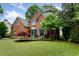 Charming brick home featuring manicured landscaping, a gabled roof, and blue trim at 5010 Winding Hills Ln, Woodstock, GA 30189
