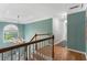 Hallway with decorative wood railing, views to the living room and views of the backyard from large window at 5010 Winding Hills Ln, Woodstock, GA 30189