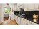 Updated kitchen with black countertops, stainless appliances, and custom cabinetry at 5010 Winding Hills Ln, Woodstock, GA 30189