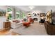 Bright living room with built-in bookcases flanking a fireplace and oversized windows overlooking a wooded lot at 5010 Winding Hills Ln, Woodstock, GA 30189