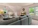 Cozy living room featuring a sectional sofa, a large window view, and television for comfortable living at 5010 Winding Hills Ln, Woodstock, GA 30189