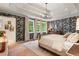 Spacious main bedroom features three large windows that provide lots of natural light and stylish wallpaper at 5010 Winding Hills Ln, Woodstock, GA 30189