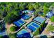 Aerial shot of multiple tennis courts and clubhouse, surrounded by lush green trees and community pool at 5010 Winding Hills Ln, Woodstock, GA 30189