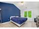 Bedroom with a blue accent wall and a large window with a view of the trees at 5174 Ridge Tarn, Acworth, GA 30102