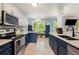 Modern kitchen with granite countertops, stainless steel appliances, and blue cabinets at 5174 Ridge Tarn, Acworth, GA 30102
