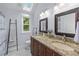 Bright bathroom featuring double sinks, granite counters, updated lighting, and a skylight at 732 S Fairfield Dr, Peachtree City, GA 30269
