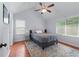 Bright bedroom with hardwood floors, ceiling fan, gray walls, and large windows providing great natural light at 732 S Fairfield Dr, Peachtree City, GA 30269