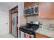 Updated kitchen with stainless steel microwave, black gas range, granite countertops, and wood cabinets at 732 S Fairfield Dr, Peachtree City, GA 30269
