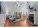 Inviting living room featuring vaulted ceiling, hardwood floors, fireplace, and a comfortable sectional sofa at 732 S Fairfield Dr, Peachtree City, GA 30269
